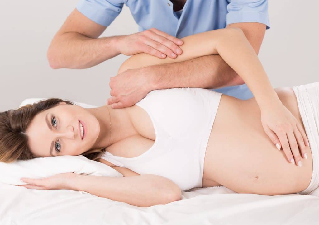 Pregnant woman with painful arm at the physiotherapist